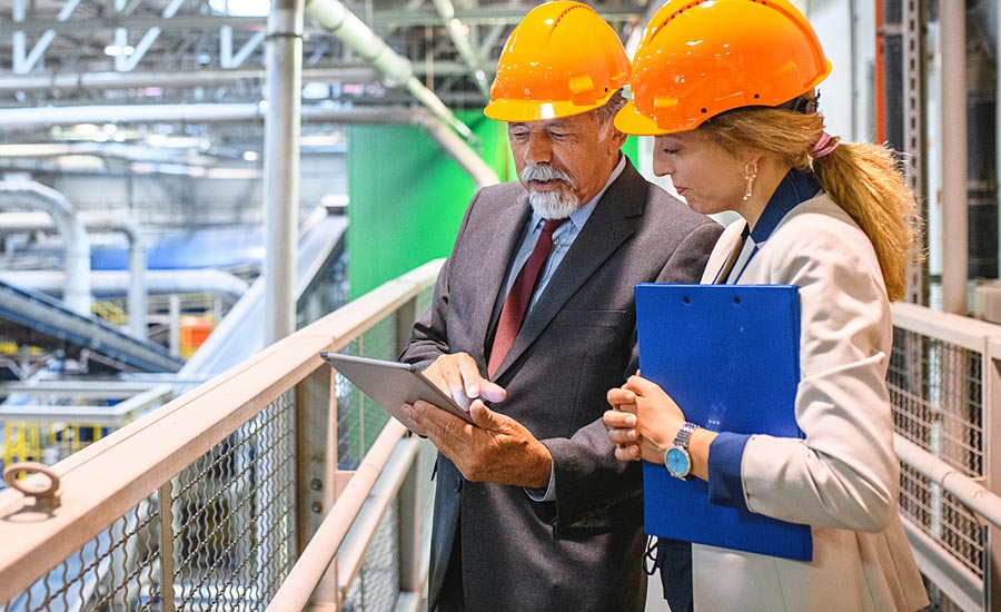 two people in hard hats in a factory setting