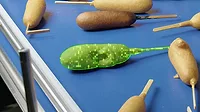 An AI-enabled vision system detects an exposed hot dog while inspecting corn dogs at a food processing facility. An AI-enabled vision system detects an exposed hot dog while inspecting corn dogs at a food processing facility.