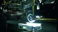 The image depicts a vintage automotive manufacturing plant, likely a Cadillac assembly line from the 1960s or 1970s. 