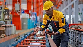 Worker inspecting production equipment in a manufacturing facility.