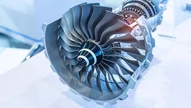 Close-up of a turbine rotor and compressor assembly used in an aircraft engine.