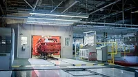 Vehicle body moving through an automotive assembly line in a manufacturing plant.