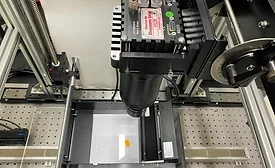 Line-scan camera inspection system mounted above a moving sample stage used for high-speed industrial quality control and machine vision applications.