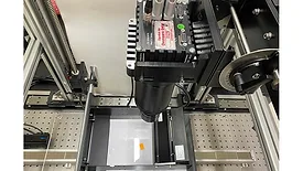 Line-scan camera inspection system mounted above a moving sample stage used for high-speed industrial quality control and machine vision applications.