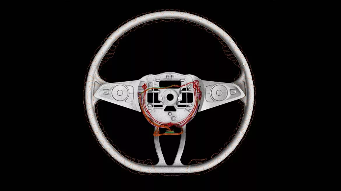 Industrial computed tomography (CT) scan of an automotive steering wheel, revealing internal wiring, electronic components, and structural features for nondestructive inspection and quality analysis.