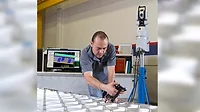 Technician Performing Portable Metrology Inspection Technician measuring a metal assembly with a portable metrology system.