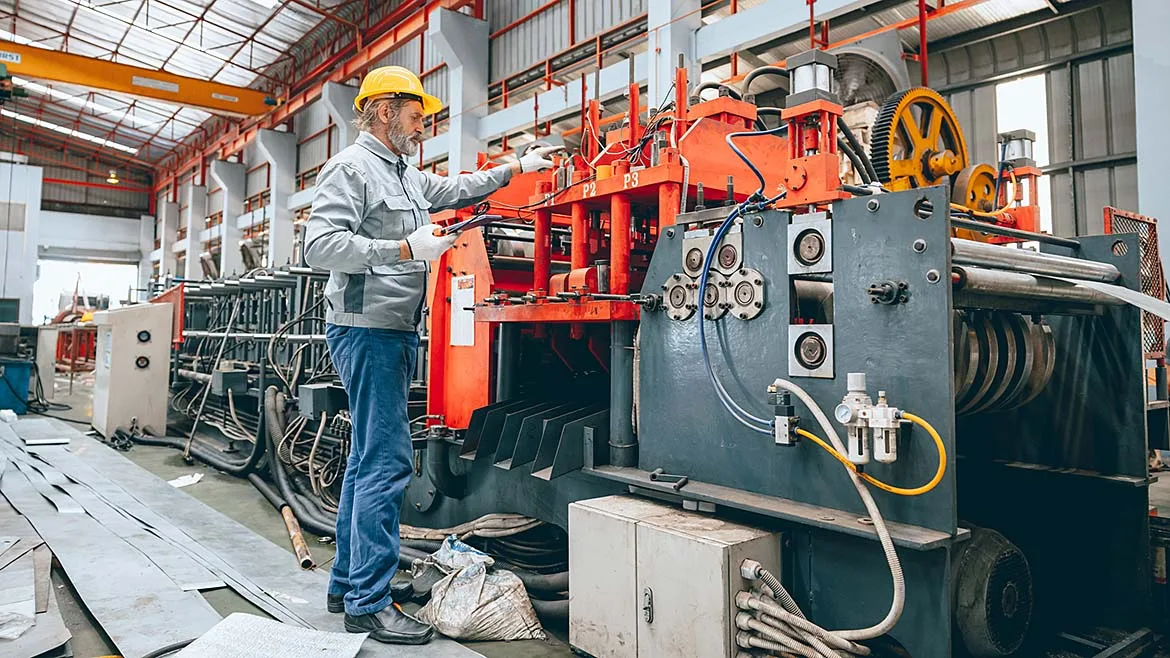 Manufacturing Technician Operating Industrial Machinery Manufacturing technician operating industrial machinery on a factory floor.