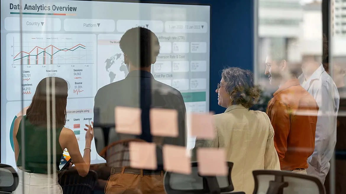 Business Team Reviewing Analytics Dashboard Business team reviewing analytics dashboards during a meeting.