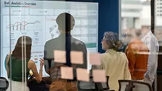 Business Team Reviewing Analytics Dashboard Business team reviewing analytics dashboards during a meeting.