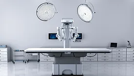 Robotic surgery system positioned over an operating table in a surgical suite.