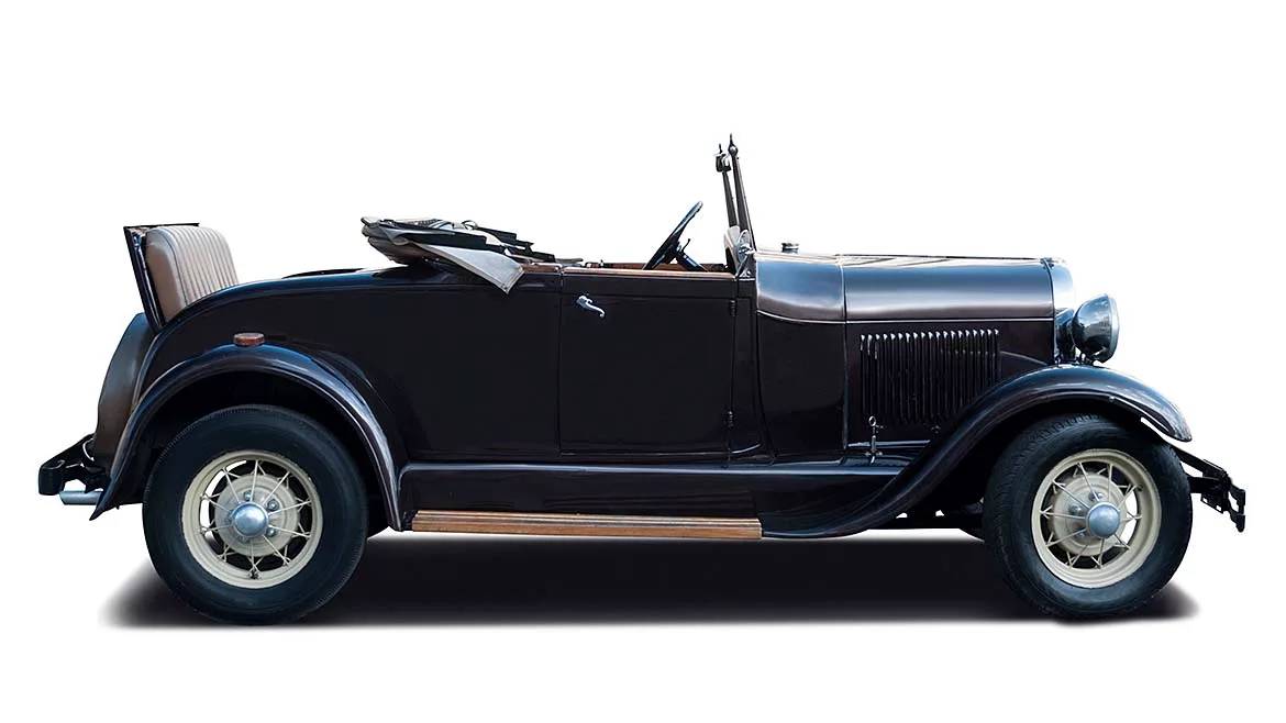 Vintage Convertible Automobile – Classic Car Side Profile Side view of a vintage black convertible automobile with whitewall tires and a folded soft top, isolated on a light background.