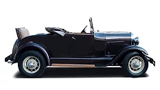 Side view of a vintage black convertible automobile with whitewall tires and a folded soft top, isolated on a light background.