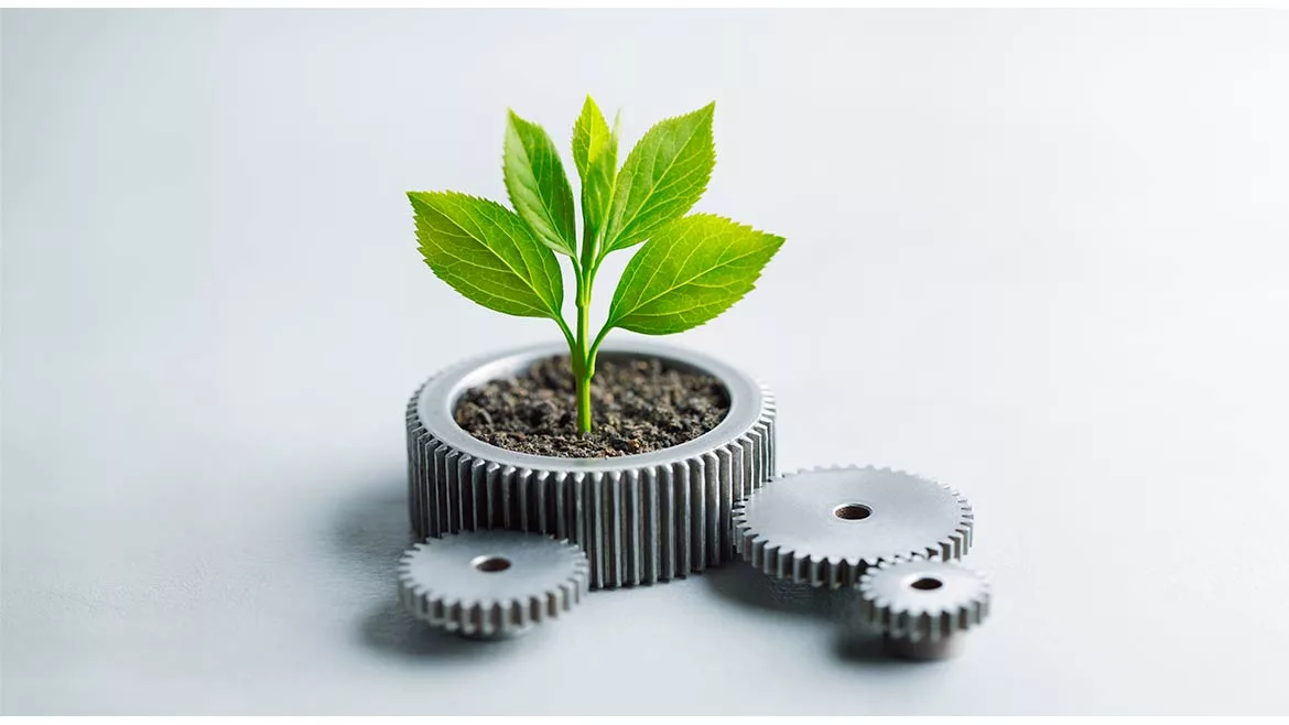 Large silver grooved gear containing dirt and a green plant, with three smaller gears connected to it.