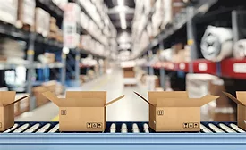 Cardboard boxes on conveyor rollers inside a warehouse ready to be shipped by courier for distribution.