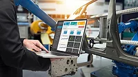 The male manager's finger is on a laptop checking the monitoring system application The male manager's finger is on a laptop checking real-time production monitoring system application in a smart factory industrial.