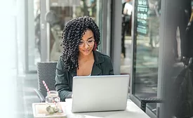 March 2024 Minitab feature image of young black female with laptop sitting outside.