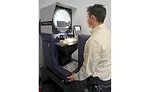 A metrology student inspects thread details of a go-no gage on the optical comparator. 