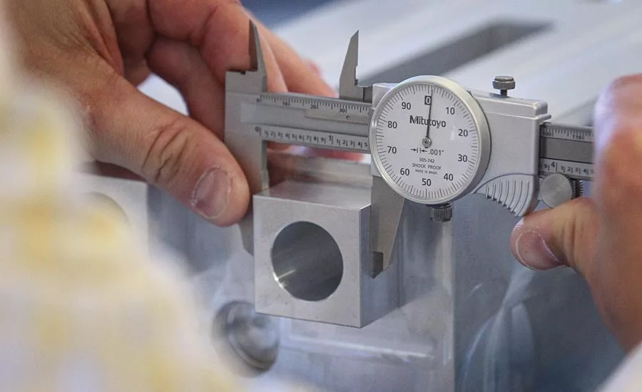 A metrology student inspects a training part supplied by industry partners.