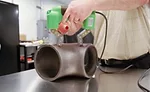 Magnetic particle inspection using an AC magnetic yoke and dry method magnetic particles.