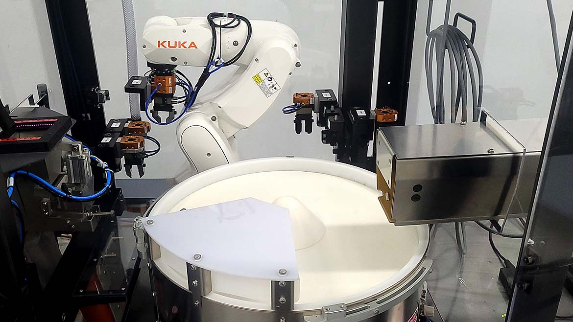 Figure 1: Using custom designed end-of-arm tooling (EOAT) on an automatic tool changer, this flexible vision-guided robot system can handle part sizes ranging from 0.1mm in diameter up to 100 x 30 x 30.