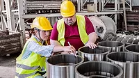 Engineers working in metal manufacturing industry Engineers working in metal manufacturing industry, doing quality control of the production with tablet.