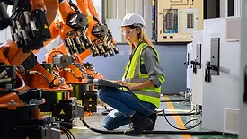 Female engineer worker working with robotic machine automation.