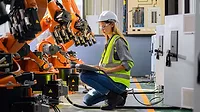 Female engineer worker working with robotic machine automation.