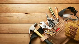 Tools in tool belt laying on a wooden table.