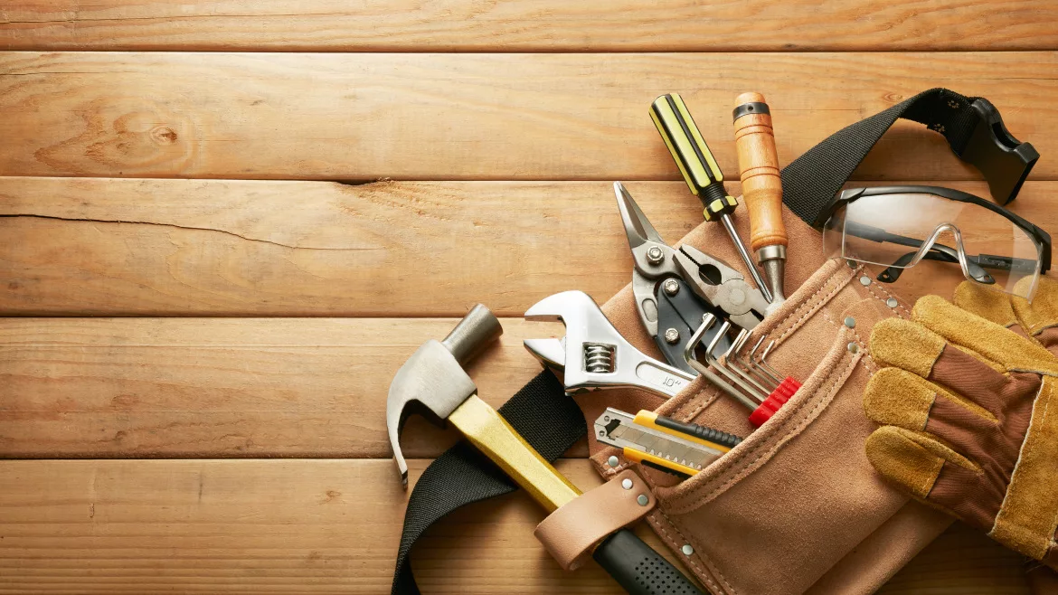 Tools in tool belt laying on a wooden table.