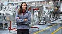 Female engineer standing against car chassis Portrait of female engineer, with crossed arms, standing against car chassis.