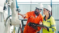 Engineers training and having a discussion in a robot development plant.