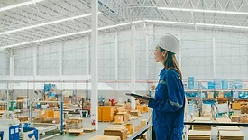 Asian female industrial engineer uses a tablet while standing in manufacturing factory. Getty Images 1813062663.