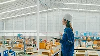 Asian female industrial engineer uses a tablet while standing in manufacturing factory. Getty Images 1813062663.