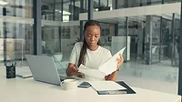 A young African American woman doing paperwork in a modern office. A young African American woman doing paperwork in a modern office.