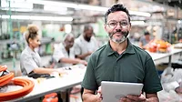 Manager using digital tablet Face of Quality column feature image of manager using digital tablet in a factory