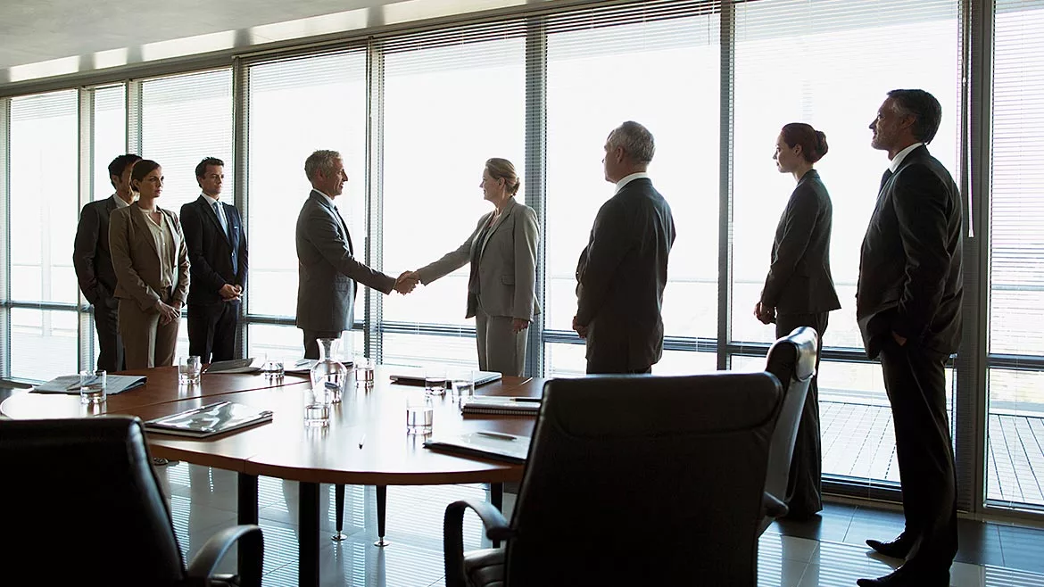 Business people shaking hands in conference room