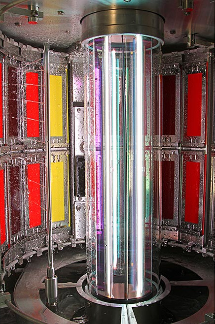 Xenon-arc weathering test chamber with centred xenon lamps, optical filter, and water spray onto a specimen rack.