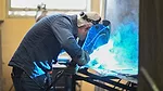 05 QM 0124 Lara Threet Column Industrial Technology Program. A student with a welding mask working on a project. 