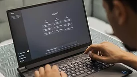 QM 0124 Software feature. Man on laptop using ChatGPT.