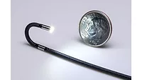 Articulated 2.2 mm OD video borescope next to a dime.