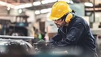 Man in hardhat working in an industrial factory.