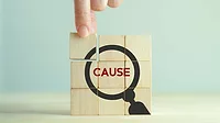 Problems and root cause analysis concept Blocks stacked in a square, pieces together form an illustration of a magnifying glass with the word "CAUSE" in the center.