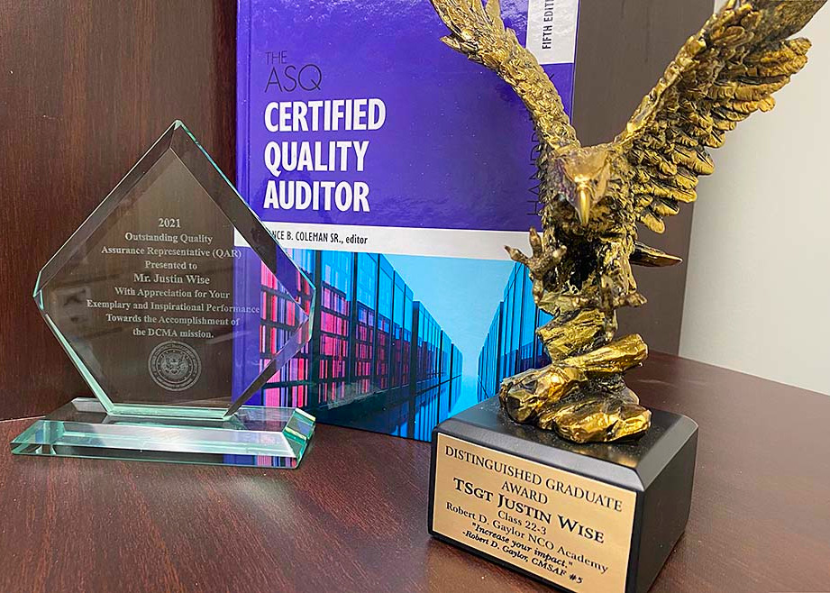 Picture of two of John Wise's awards and a Certified Quality Auditor book