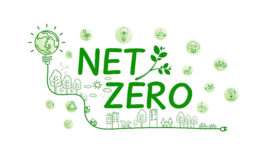 Net Zero illustration in green with globe lightbulb and climate change icons in bubble clouds.