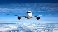 Passenger airplane flying with a blue sky and clouds in the background.