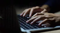 Close up of a man's hands on keyboard of lap top in the dark room Close up of a man's hands on keyboard of lap top in the dark room.
