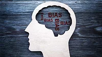 A Wooden head shape and words bias in it.