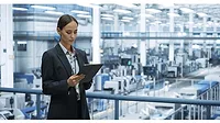 Female engineer monitoring and analyzing conditions at a modern tech electronics factory. Female engineer monitoring and analyzing conditions at a modern tech electronics factory using a tablet.