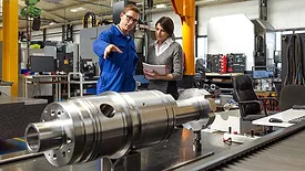 Managing director talking to an employee on the factory floor.