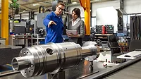 Managing director talking to an employee on the factory floor.